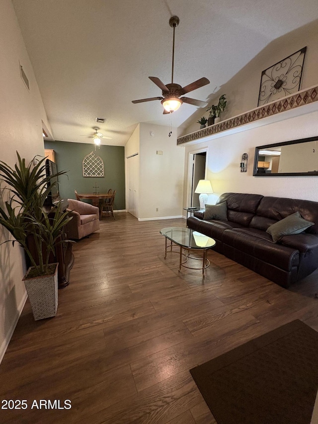 living room featuring dark wood-type flooring, high vaulted ceiling, and ceiling fan