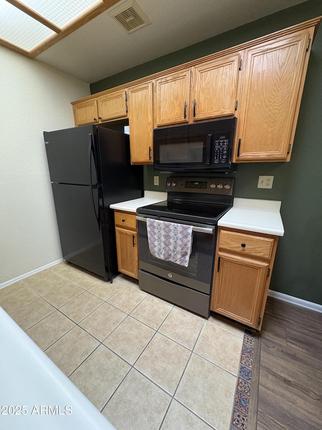 kitchen featuring light tile patterned floors and black appliances