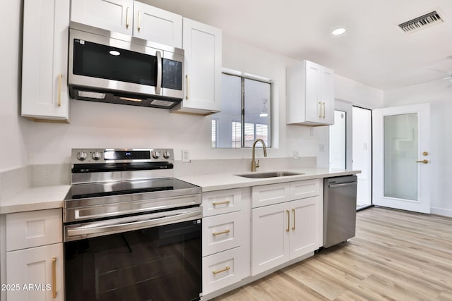 5510 E Dallas St, Mesa, AZ 85205 - kitchen with stainless steel appliances, a sink, light countertops, white cabinetry, and recessed lighting
