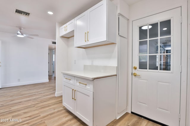 5510 E Dallas St, Mesa, AZ 85205 - kitchen with white cabinets, light wood-type flooring, ceiling fan, light countertops, and baseboards