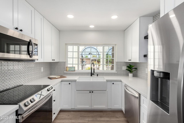 5211 E Winchcomb Dr, Scottsdale, AZ 85254 - kitchen with stainless steel appliances, light countertops, white cabinets, backsplash, and light wood-type flooring