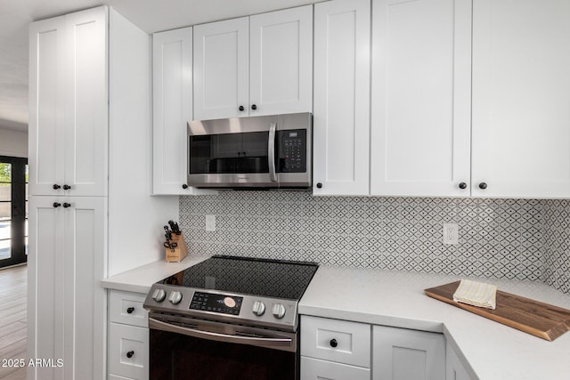 5211 E Winchcomb Dr, Scottsdale, AZ 85254 - kitchen featuring stainless steel appliances, light countertops, white cabinetry, and decorative backsplash