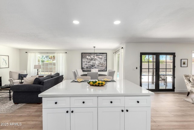 5211 E Winchcomb Dr, Scottsdale, AZ 85254 - kitchen with open floor plan, light wood-type flooring, white cabinets, a chandelier, and recessed lighting