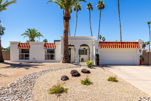 5211 E Winchcomb Dr, Scottsdale, AZ 85254 - view of front facade featuring stucco siding, a garage, driveway, and a tile roof