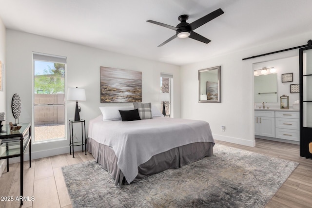 5211 E Winchcomb Dr, Scottsdale, AZ 85254 - bedroom featuring light wood-type flooring, connected bathroom, and a ceiling fan