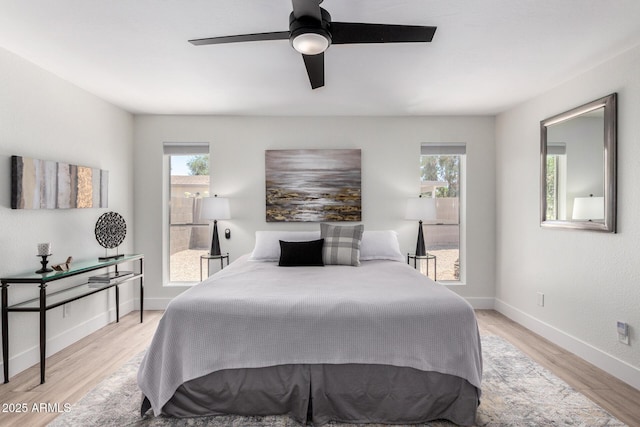 5211 E Winchcomb Dr, Scottsdale, AZ 85254 - bedroom with multiple windows, light wood finished floors, and ceiling fan