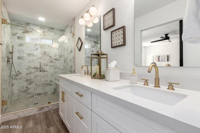 5211 E Winchcomb Dr, Scottsdale, AZ 85254 - bathroom featuring a marble finish shower, double vanity, wood finished floors, and a ceiling fan
