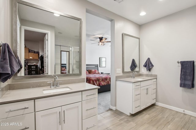 bathroom with ceiling fan, vanity, and a shower with door