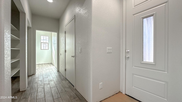 hall featuring a textured wall and wood finish floors