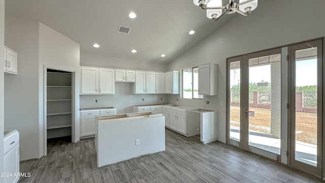 kitchen with recessed lighting, wood finished floors, visible vents, white cabinets, and vaulted ceiling