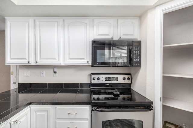 2228 N 52nd St Unit 140, Phoenix, AZ 85008 - kitchen featuring black microwave, electric range, white cabinets, and tile countertops