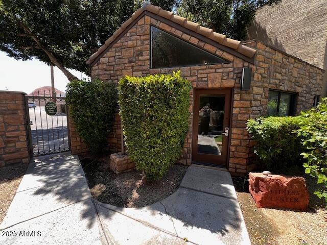 2228 N 52nd St Unit 140, Phoenix, AZ 85008 - entrance to property featuring a gate and stone siding