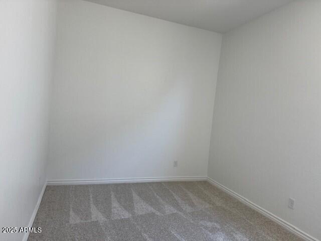 carpeted empty room with baseboards