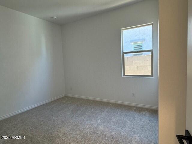 empty room with carpet floors and baseboards
