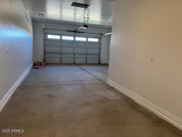 garage with baseboards and a garage door opener