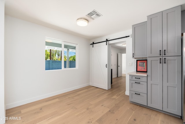 kitchen featuring gray cabinets, baseboards, and light wood-style flooring