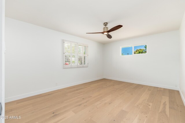 spare room featuring ceiling fan, healthy amount of natural light, light wood-style flooring, and baseboards