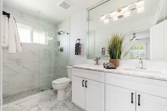 bathroom with marble finish floors, a marble finish shower, toilet, and ceiling fan