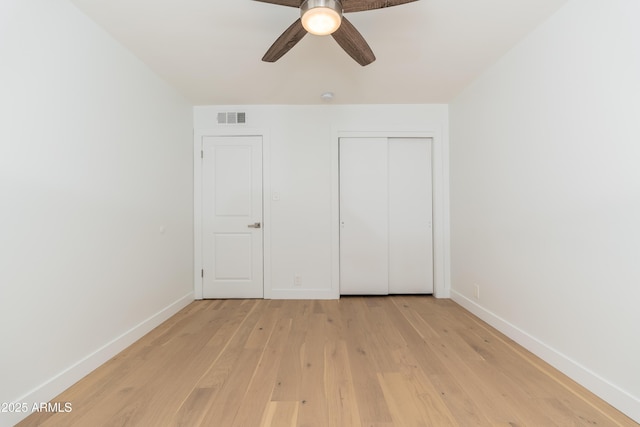 unfurnished bedroom featuring light wood-style flooring, baseboards, a closet, and a ceiling fan