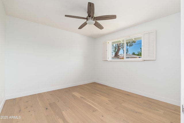 spare room featuring light wood-style floors, baseboards, and ceiling fan