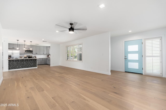 unfurnished living room featuring a ceiling fan, light wood finished floors, baseboards, and recessed lighting