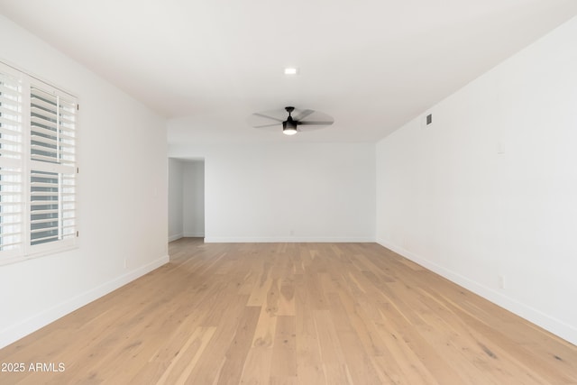 unfurnished room featuring ceiling fan, light wood-style flooring, and baseboards
