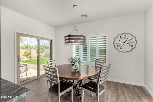 dining area featuring visible vents, light wood-type flooring, a wealth of natural light, and baseboards