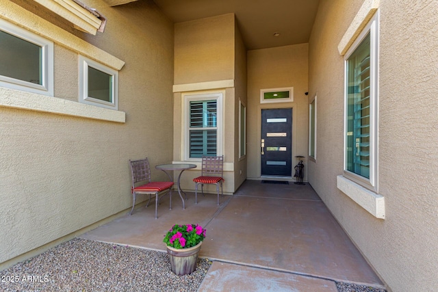 property entrance with a patio area and stucco siding