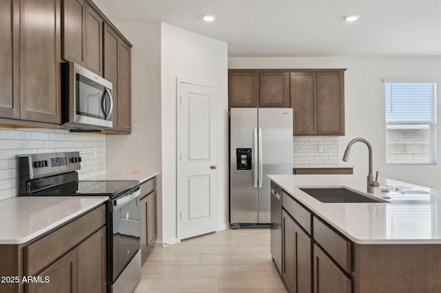 25425 W Graham Trl, Buckeye, AZ 85326 - kitchen with a sink, tasteful backsplash, appliances with stainless steel finishes, and an island with sink