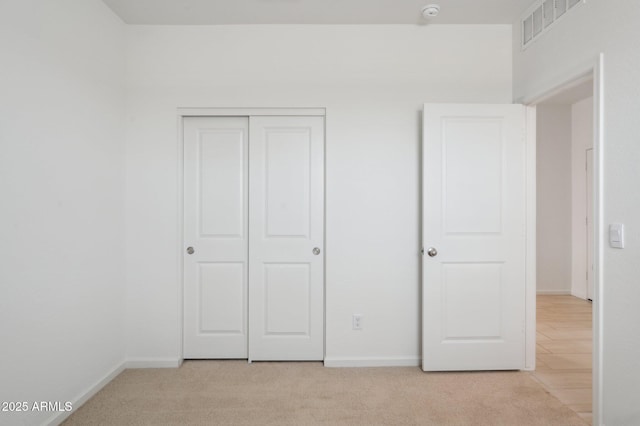 25425 W Graham Trl, Buckeye, AZ 85326 - unfurnished bedroom with light carpet, a closet, baseboards, and visible vents