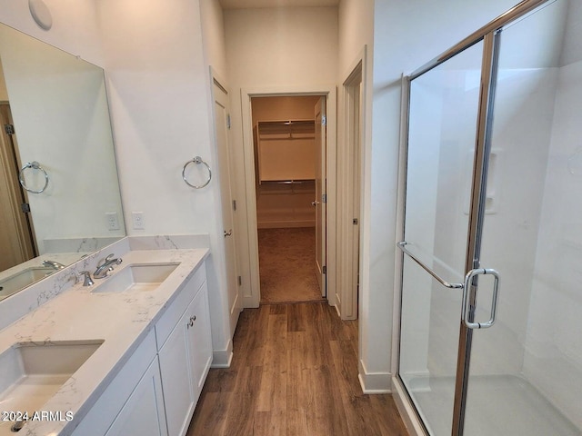 bathroom with walk in shower, vanity, and hardwood / wood-style floors