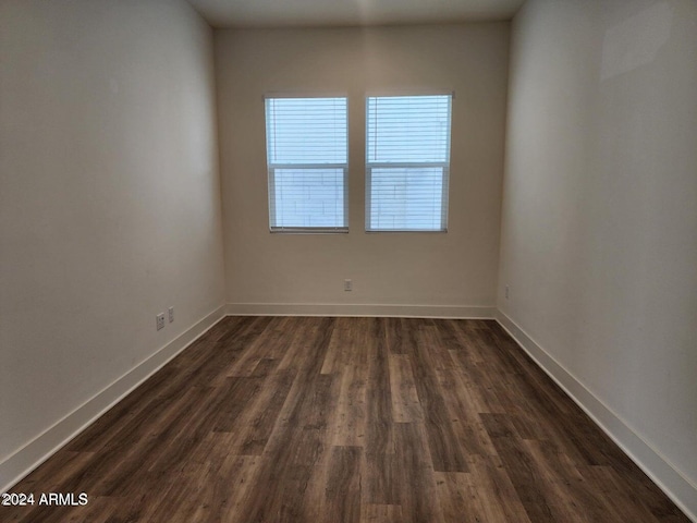 spare room featuring dark hardwood / wood-style flooring and a healthy amount of sunlight