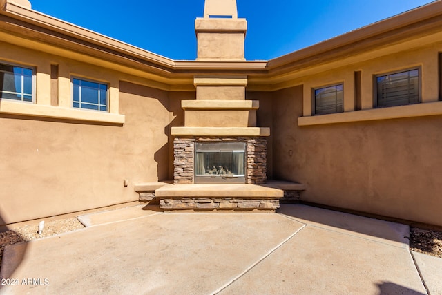 view of patio featuring an outdoor stone fireplace