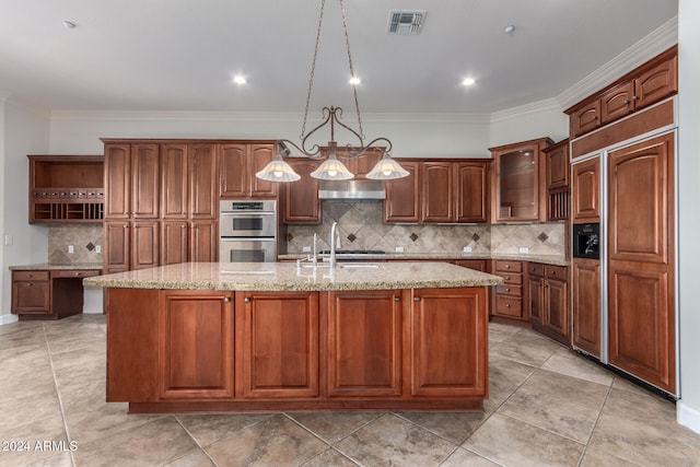 kitchen with a center island with sink, tasteful backsplash, wall chimney exhaust hood, stainless steel double oven, and pendant lighting