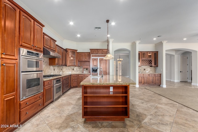 kitchen with stainless steel appliances, a center island with sink, sink, light stone counters, and hanging light fixtures