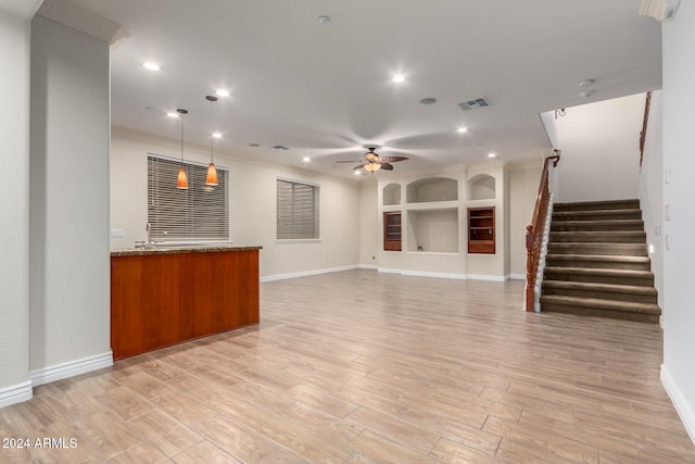 interior space with stone countertops, ceiling fan, decorative light fixtures, and light hardwood / wood-style flooring