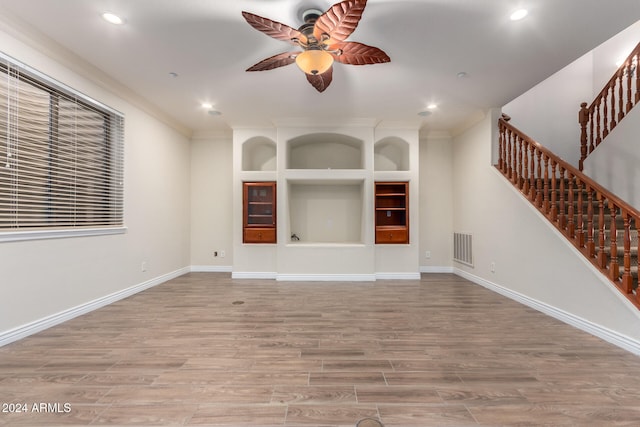 unfurnished living room with ceiling fan, ornamental molding, and light hardwood / wood-style flooring