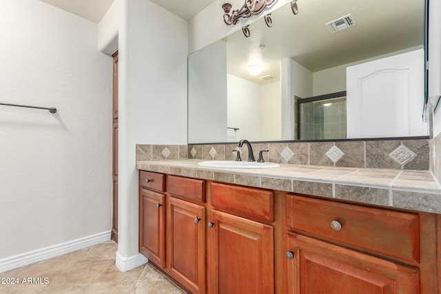 bathroom featuring vanity, tile patterned floors, an enclosed shower, and tasteful backsplash