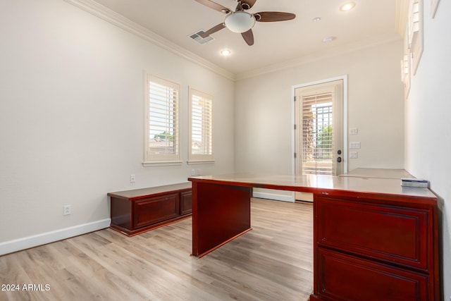 unfurnished office with built in desk, ceiling fan, light hardwood / wood-style flooring, and ornamental molding