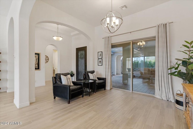 sitting room featuring light wood-type flooring and a notable chandelier