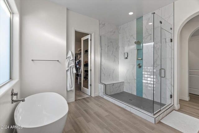 bathroom with hardwood / wood-style flooring and plus walk in shower