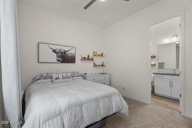 bedroom with ceiling fan, ensuite bath, sink, and light hardwood / wood-style flooring