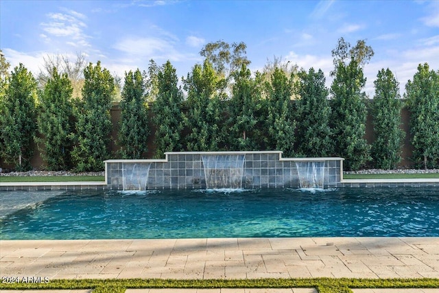 view of swimming pool with pool water feature