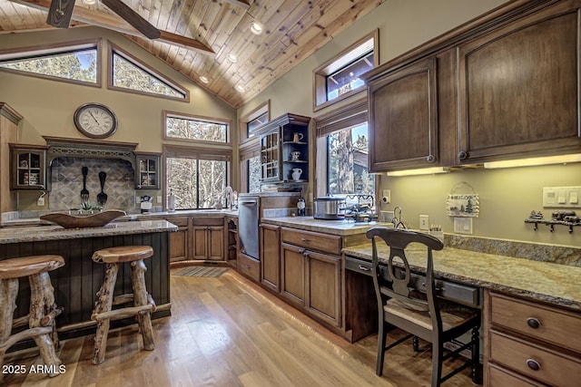 kitchen with glass insert cabinets, light stone countertops, wood ceiling, and light wood-style flooring