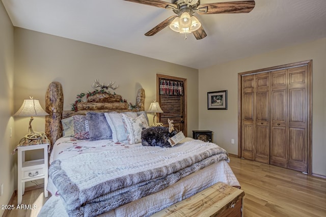 bedroom featuring a closet, baseboards, light wood-style floors, and ceiling fan