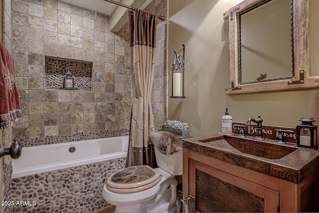 bathroom with toilet, vanity, and tiled shower / bath