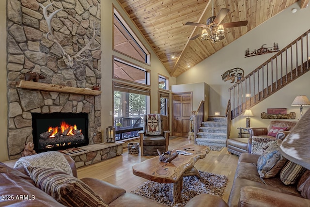 living room with stairway, a fireplace, wooden ceiling, wood finished floors, and high vaulted ceiling