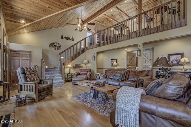 living area with wood ceiling, stairs, wood finished floors, high vaulted ceiling, and a ceiling fan