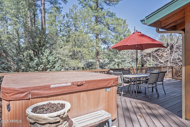 wooden terrace featuring outdoor dining space and a hot tub