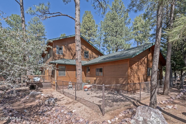 rear view of house with a deck and fence